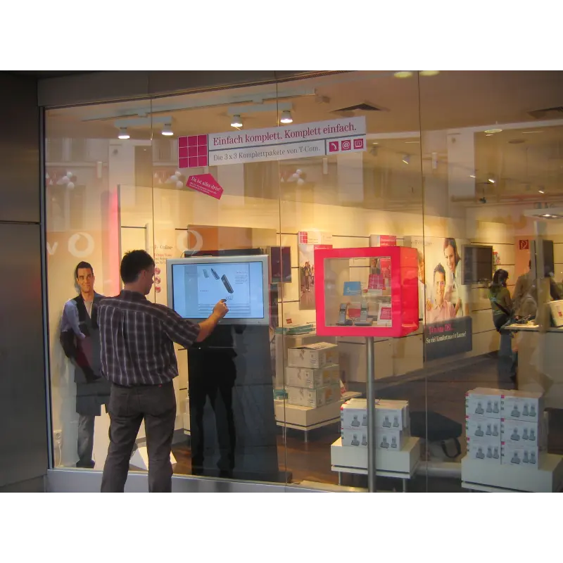 Interactive touch-enabled glass window at an auto dealership with touch-to-play digital engagement experience
